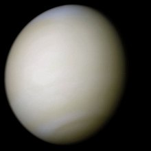 Venus in approximately true colour, a nearly uniform pale cream, although the image has been processed to bring out details.[1] The planet's disc is about three-quarters illuminated; almost no variation or detail can be seen in the clouds