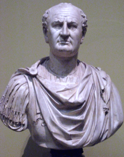 Front view of a bust. He is balding and wears a Roman tunic.